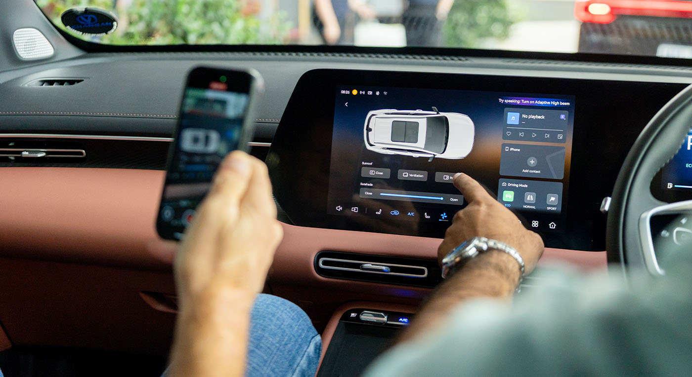 A person in Changan UNI-S SUV uses a smartphone and touches the car's touchscreen, displaying a car interface. The scene conveys modern technology and connectivity.